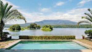 A swimming pool with a view of a lake and distant mountains. - Isleta El Espino Ecolodge (Granada)