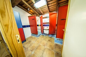 A bathroom with red doors, a tiled floor, and a wooden ceiling. - Hotel Rural La Noria (Ciudad Rodrigo)