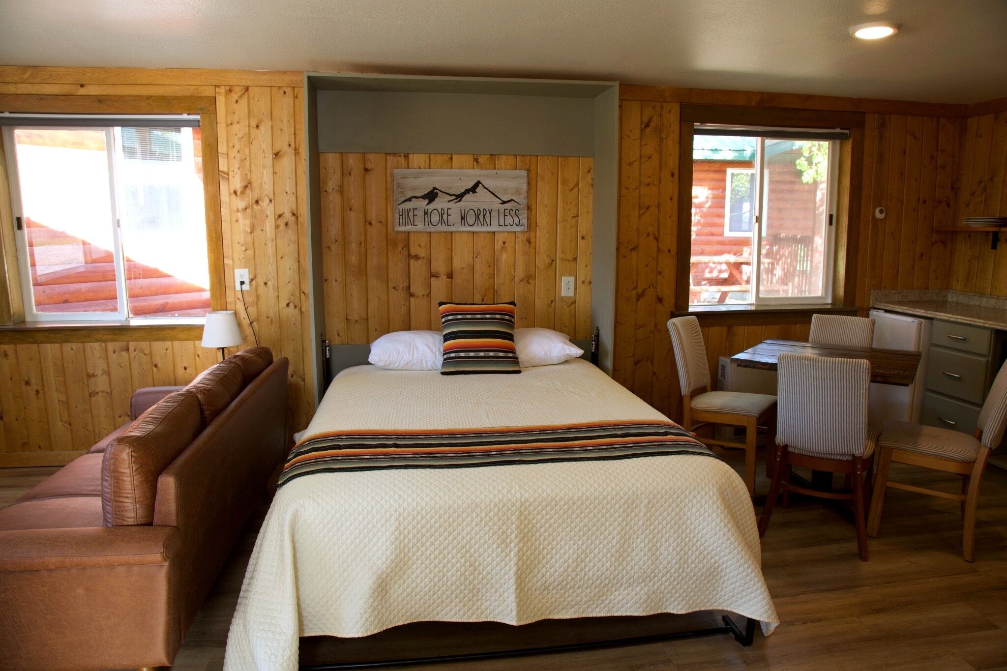 A room with a bed, a desk, a chair, and a couch.