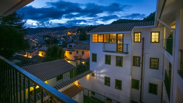 Un edificio de varios pisos con balcones y ventanas, visto desde un balcón.