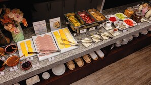 Un bufé con diversos alimentos y utensilios.