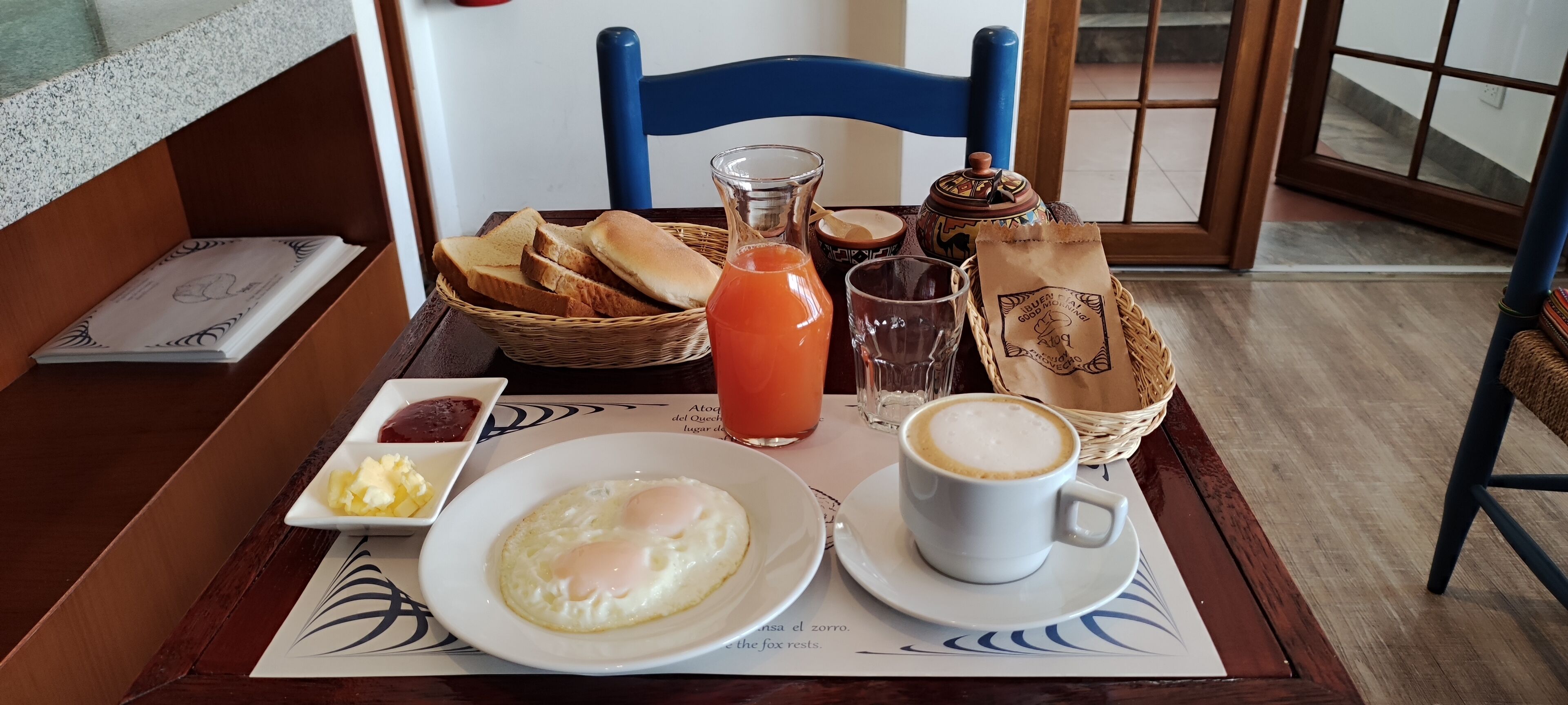 A breakfast setting with toast, eggs, coffee, and juice on a table.