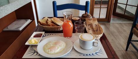 A breakfast setting with toast, eggs, coffee, and juice on a table.