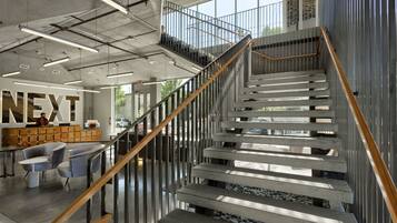Un intérieur moderne avec un escalier, un espace d’accueil et une grande fenêtre.