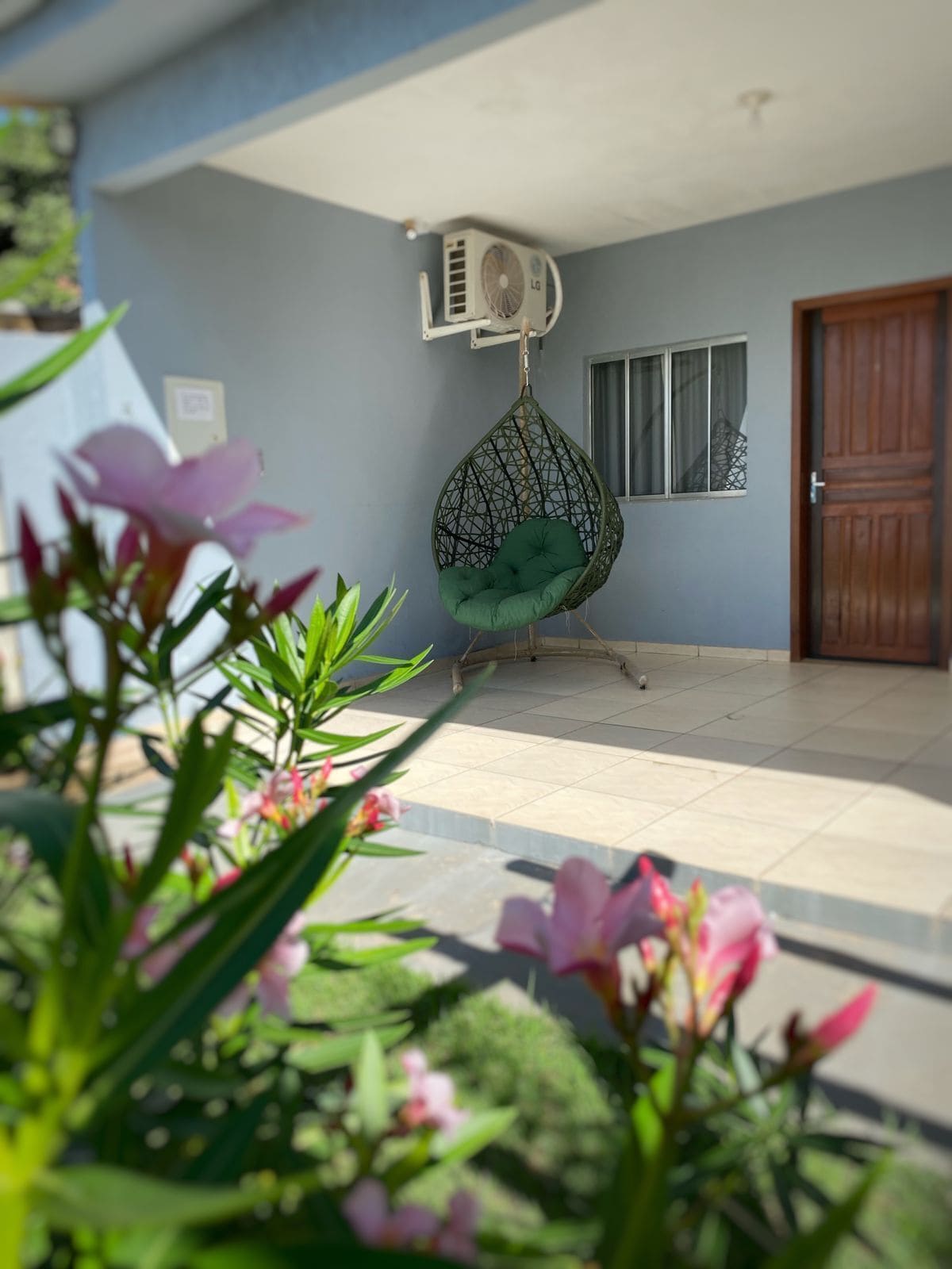 A room with a hanging chair, a ceiling fan, and a door.