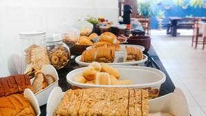 Una mesa de bufé con diversos productos de pastelería y panadería.