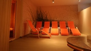 A room with a round table and four orange chairs arranged around it.