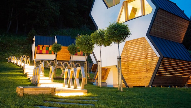 Un edificio moderno de diseño geométrico con varios niveles y un techo de diseño único.