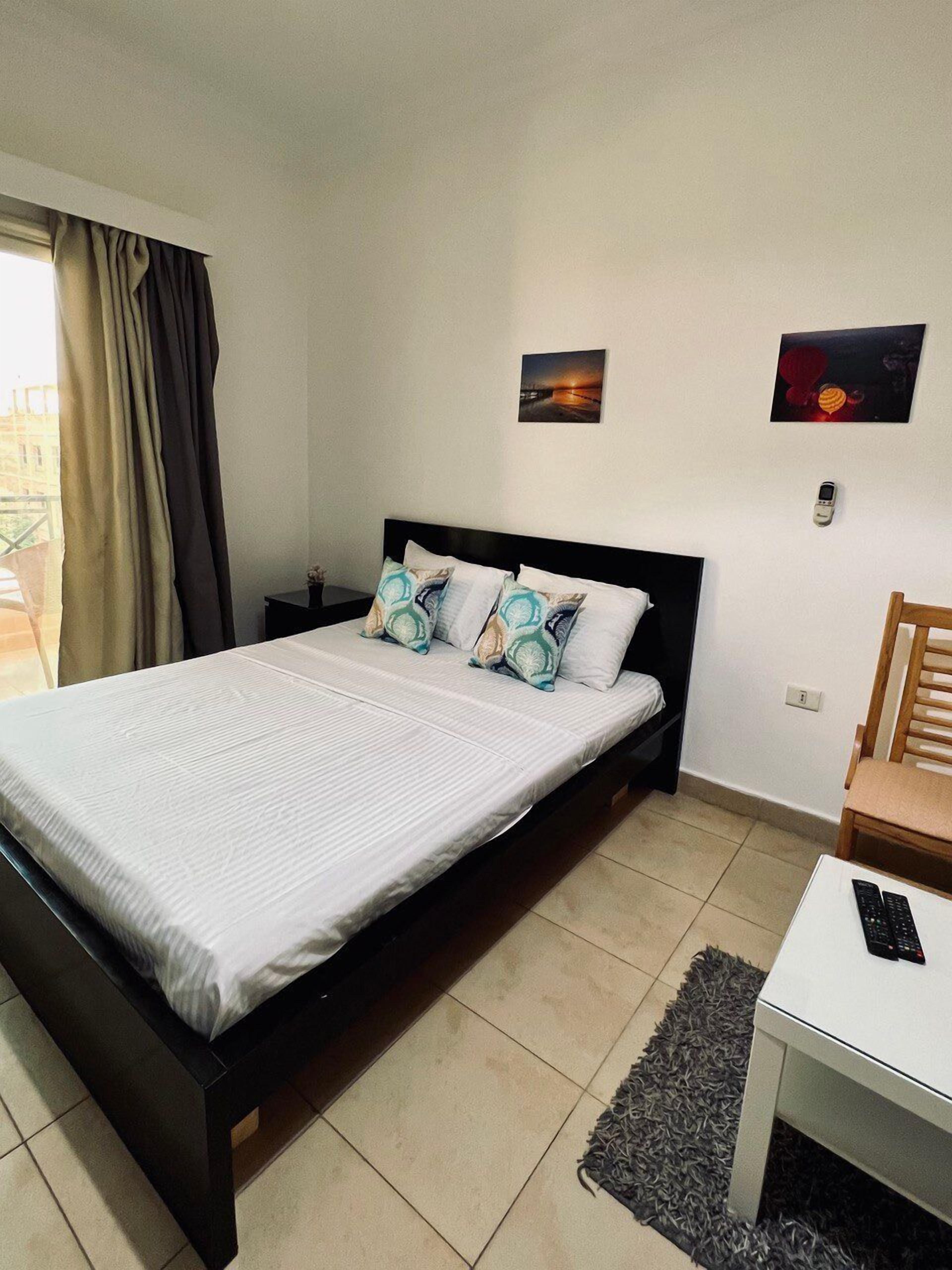 A hotel room with a bed, bedside tables, a desk, and a chair.