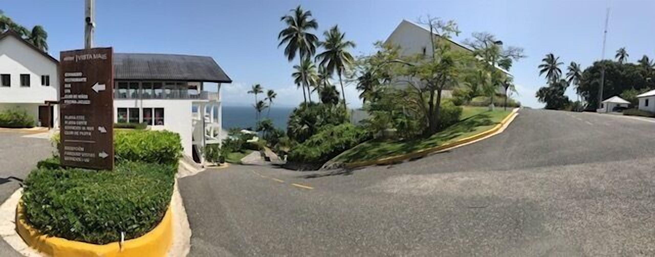 Uma estrada costeira com um indicador apontando direções para vários locais.