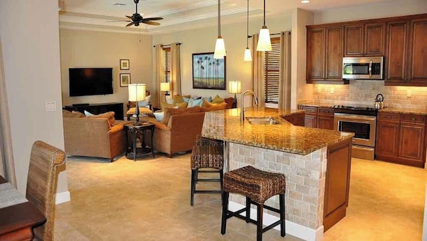 A modern kitchen with granite countertops, a built-in island, and wooden cabinets. - 3/2.5 home, custom designed with vacation in mind. (Marco Island)
