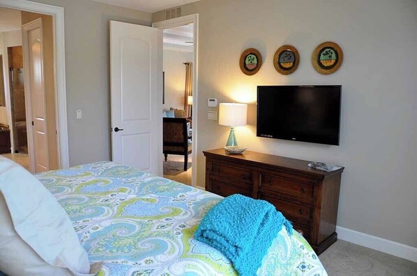 A bedroom with a bed, a dresser, a TV, and three wall-mounted clocks. - 3/2.5 home, custom designed with vacation in mind. (Marco Island)