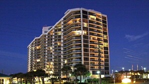 A multi-story hotel with balconies, a pool area, and a well-lit facade. -  So Cozy & Serene Perfect Getaway Gulf Front Studio  
Private  Balcony Bch Srv  (Miramar Beach)