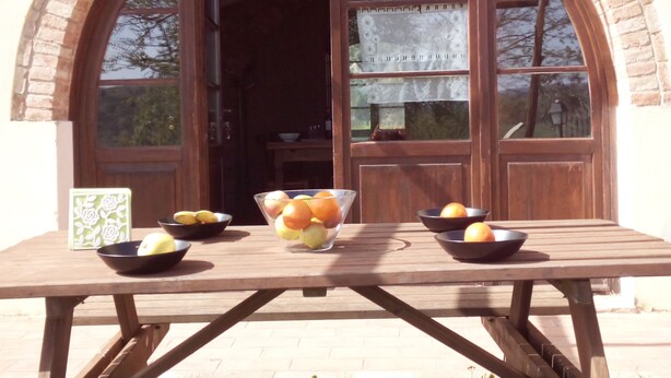 Une table en bois avec des corbeilles de fruits et un objet décoratif.