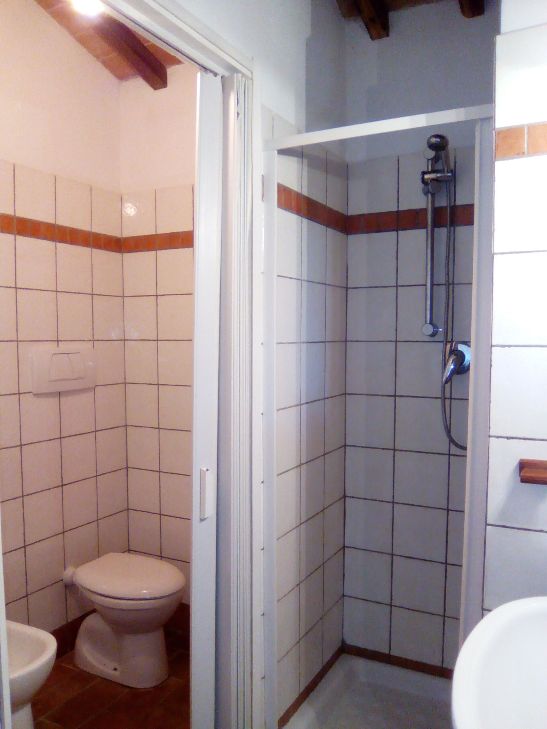 A bathroom with a toilet, a shower stall, and a sink.