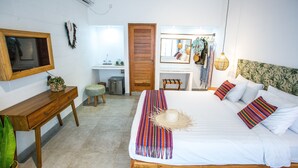 A bedroom with a bed, wooden bedside table, a small stool, a mirror, a desk, and a hanging light fixture. - Abdi Hotel & Bungalow (Gili Trawangan)