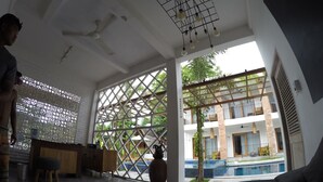 A hotel lobby with a reception desk, seating area, and a view of the outdoor pool. - Abdi Hotel & Bungalow (Gili Trawangan)