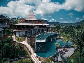 Un complexe hôtelier doté d’une grande piscine, d’une cascade et offrant une vue sur la montagne.
