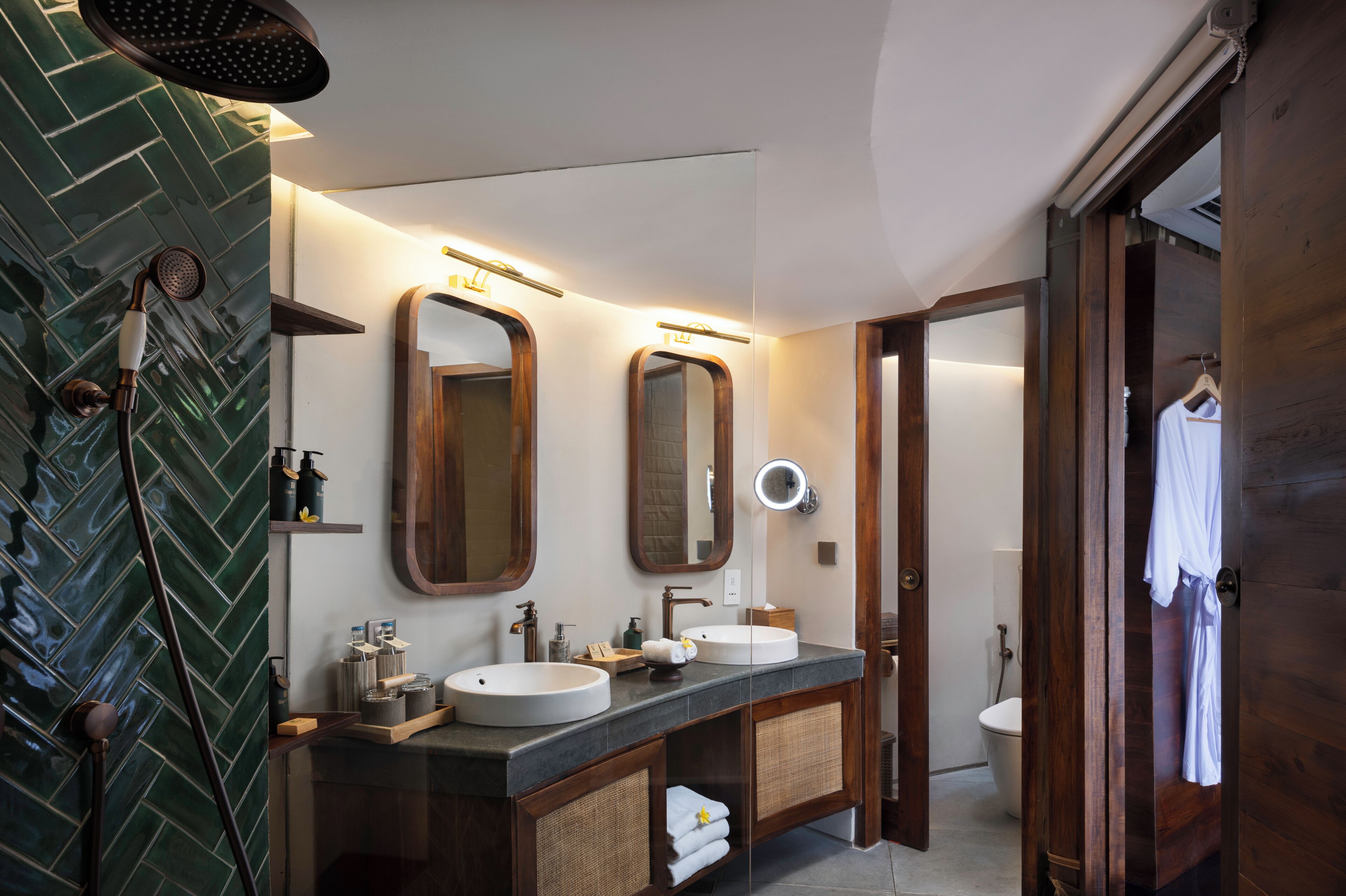 Un bagno con due lavandini, una doccia e uno specchio.