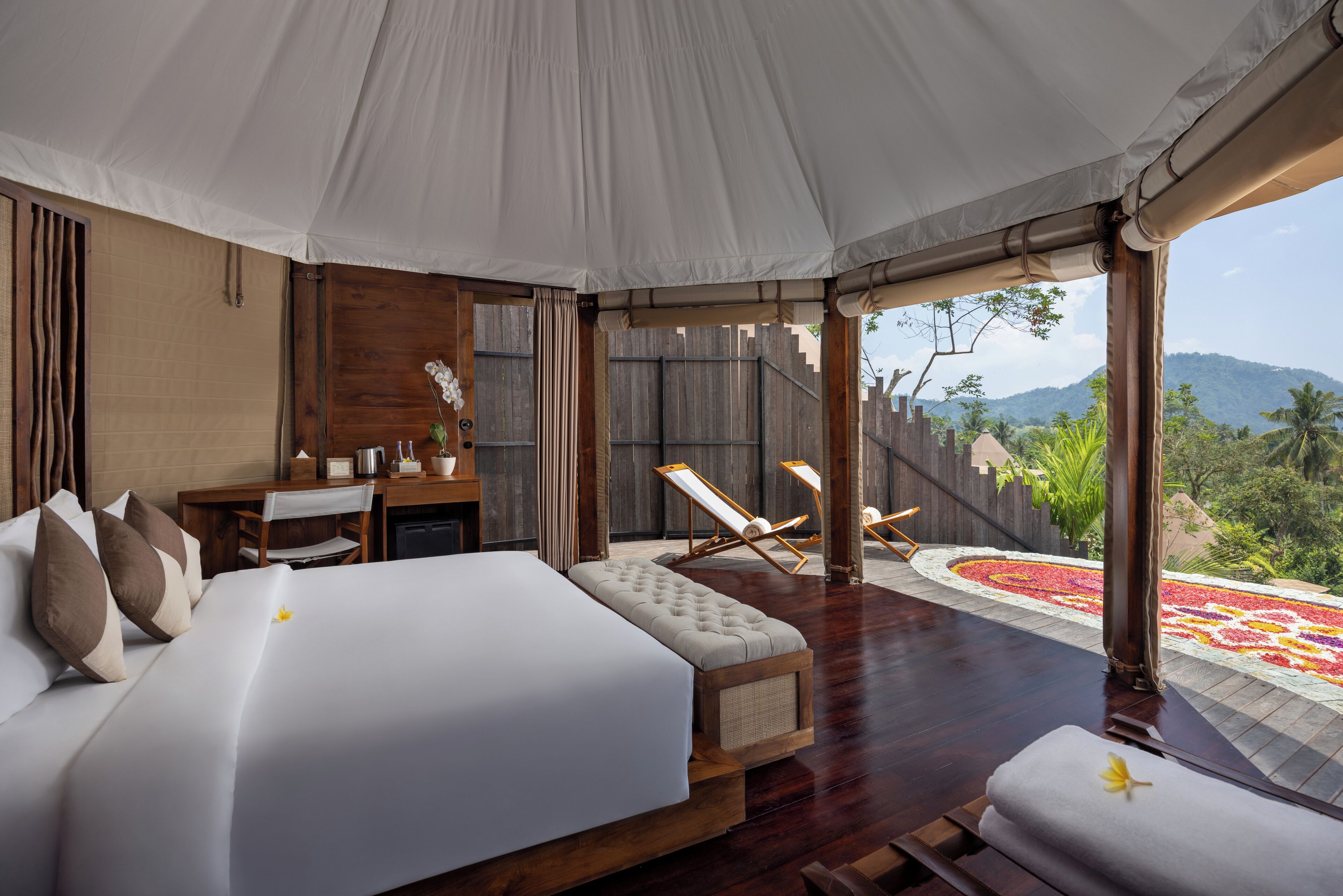 Ein geräumiges Schlafzimmer mit einem großen Bett, einem Schreibtisch und Blick auf einen angelegten Garten.
