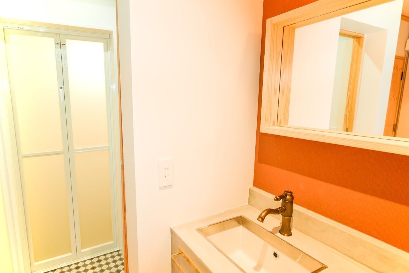 A bathroom with a white sink, a mirror, and a shower door.