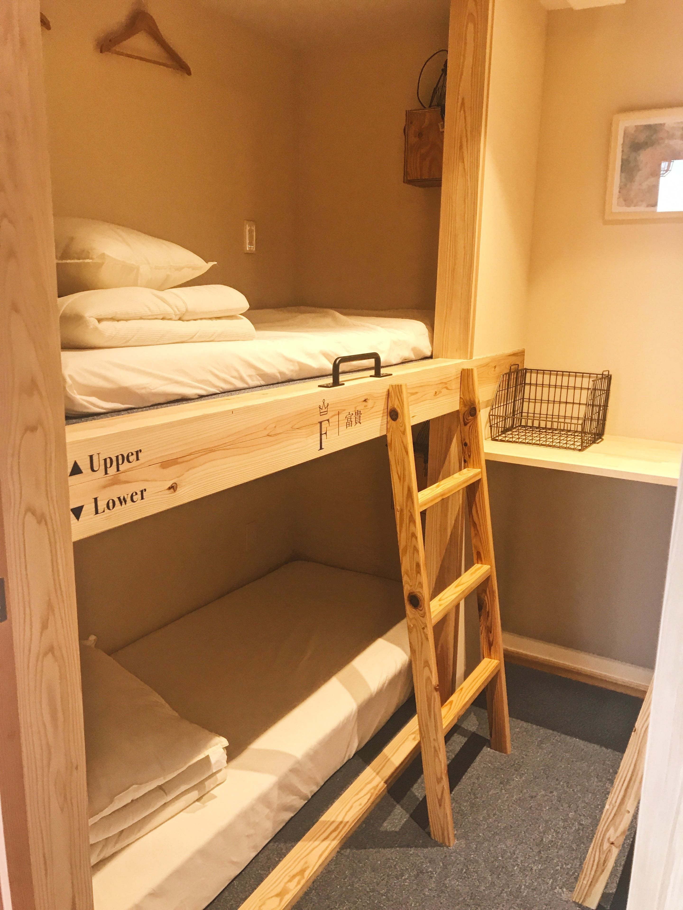 A bunk bed with a ladder, a small shelf, and a hanging hook.