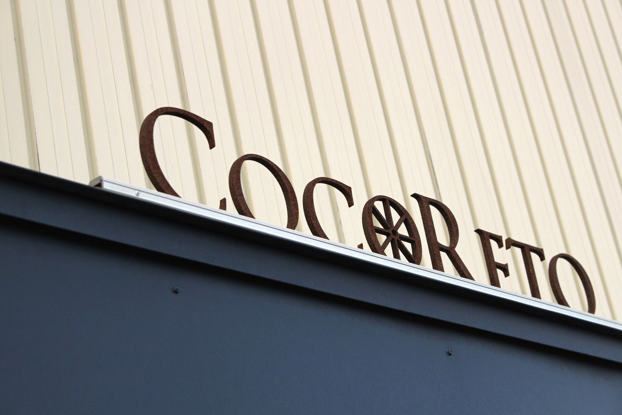 A building with a corrugated metal exterior and the word "Cocorreto" in large letters.