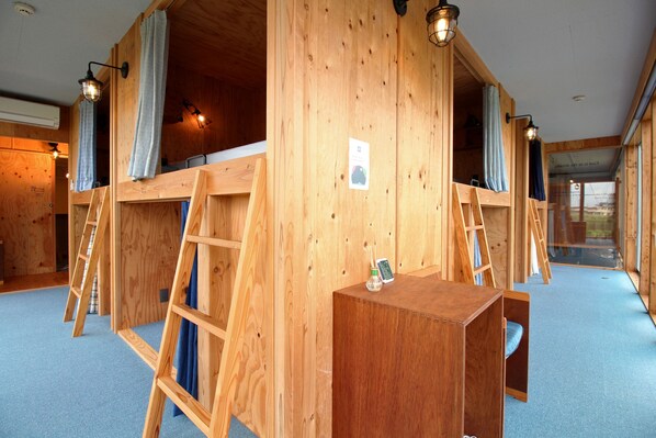 A wooden cabin with a loft bed, ladders, and a small table with a bottle and a phone. - COCORETO THE GUEST HOUSE - Hostel (Matsue)