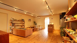 A spacious kitchen with wooden flooring, a central island, and a dining area. - COCORETO THE GUEST HOUSE - Hostel (Matsue)
