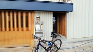 A bicycle parked outside a building with a sign reading "Cocorreto". - COCORETO THE GUEST HOUSE - Hostel (Matsue)
