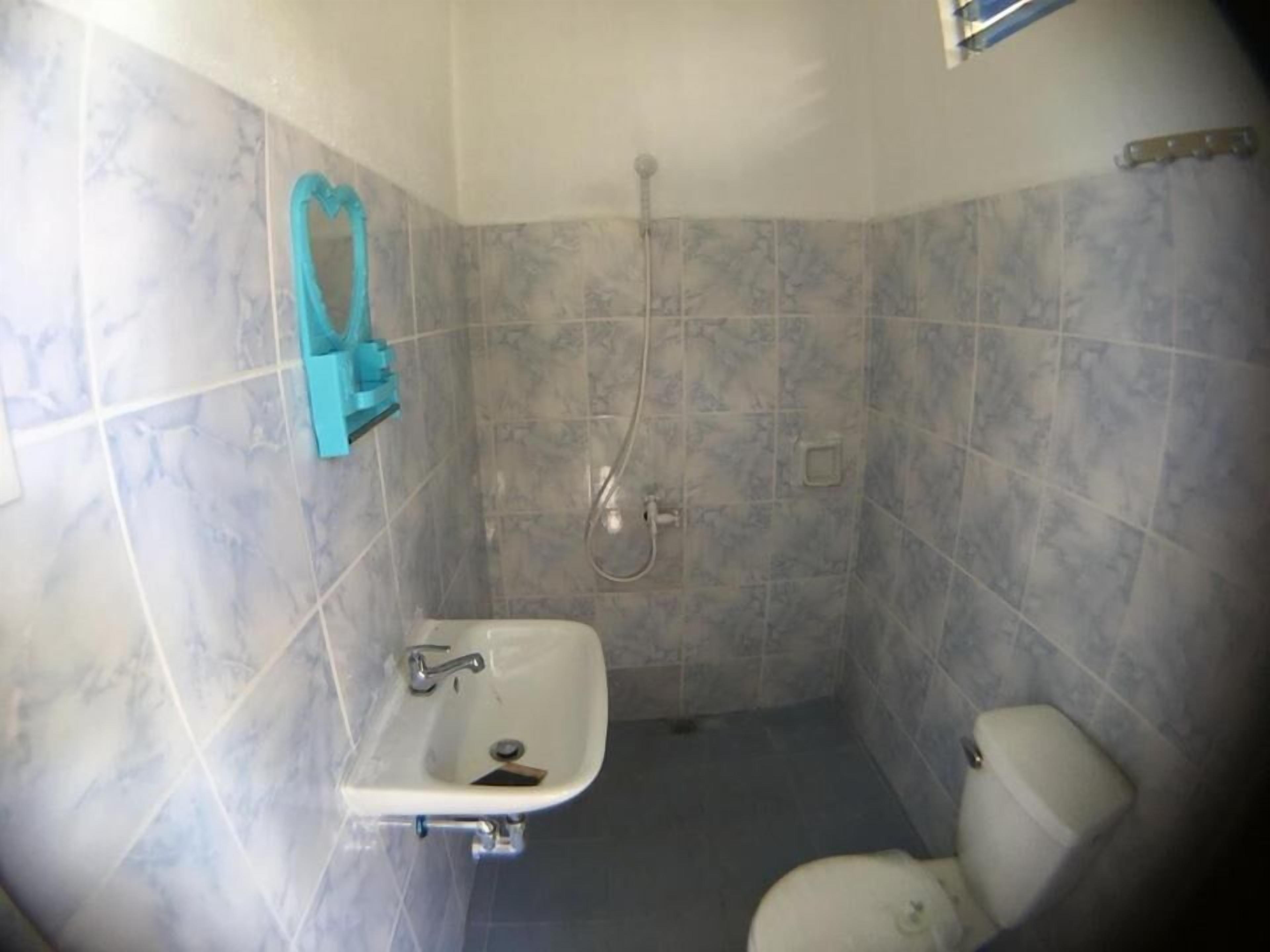A bathroom with a shower, toilet, and sink.