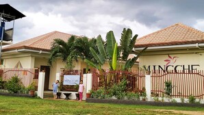 A building with a sign reading "MINGCHE" and a fenced entrance. - Mingche Apartment (Panglao)