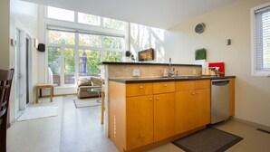 Una cucina compatta con mobili in legno, una lavastoviglie e una finestra che garantisce luce naturale.