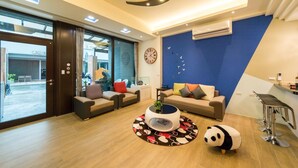 Una sala moderna con dos sofás, una mesa de centro y un peluche de panda.