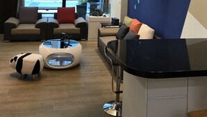 Una sala de estar moderna con un conjunto de sofás, una mesa de centro y una zona de bar.