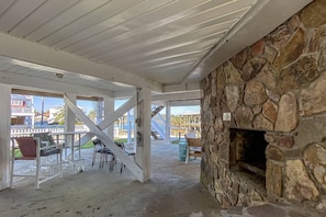 Cozy living space with a stone fireplace, staircase, and dining area.