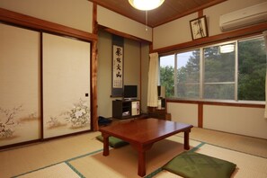 Een traditionele Japanse kamer met tatami vloeren, een lage houten tafel en glijdende deuren.