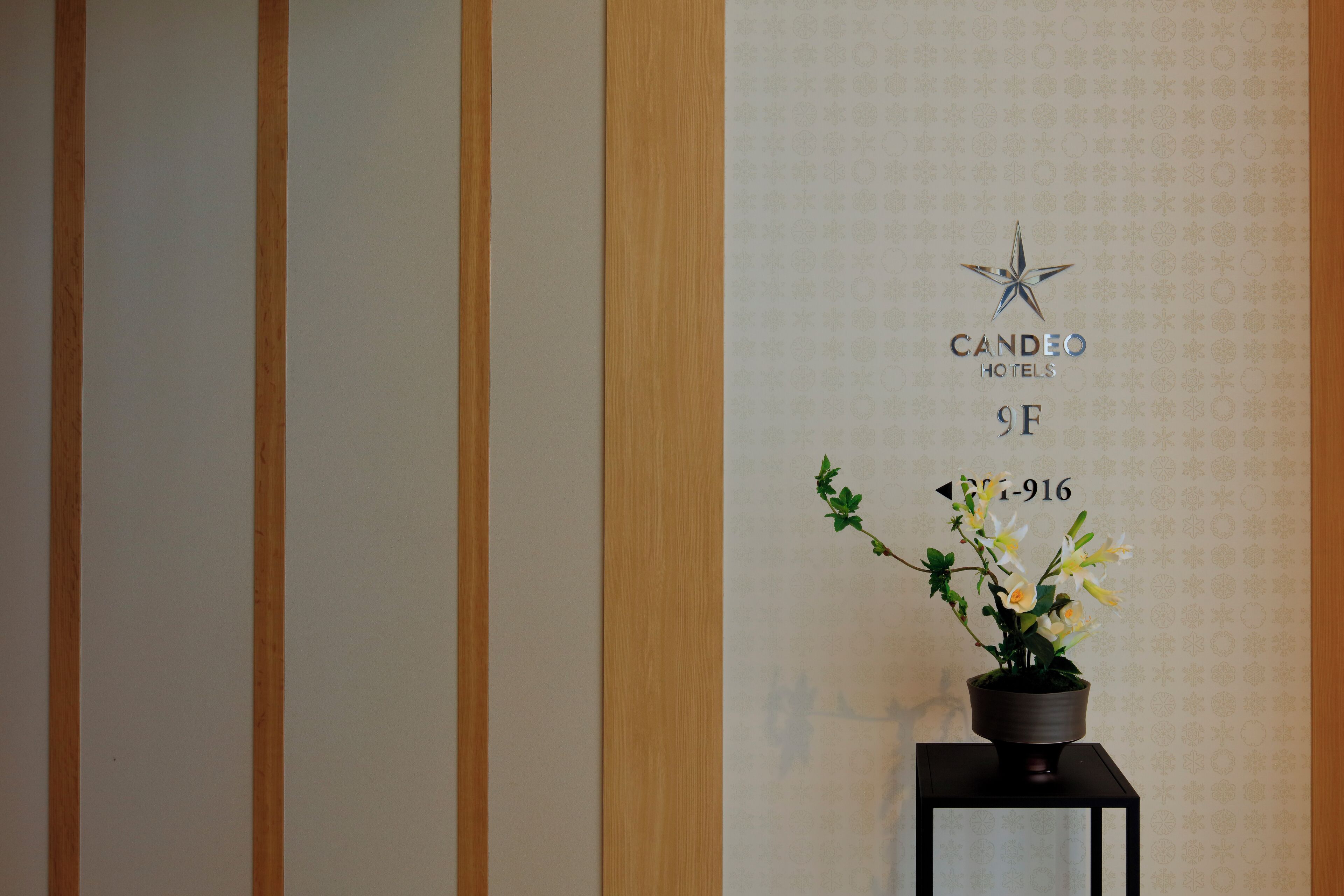 Un letrero de hotel con un logotipo de estrella, el nombre 'CANDEO HOTELS' y el número de habitación '9F-916'.