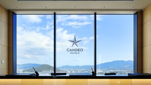 A reception desk with a view of mountains and a cityscape through large windows. - Candeo Hotels Nara Kashihara (Kashihara)