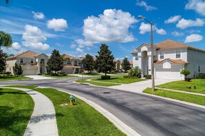 A suburban neighborhood with single-family homes, a clear sky, and a stop sign.