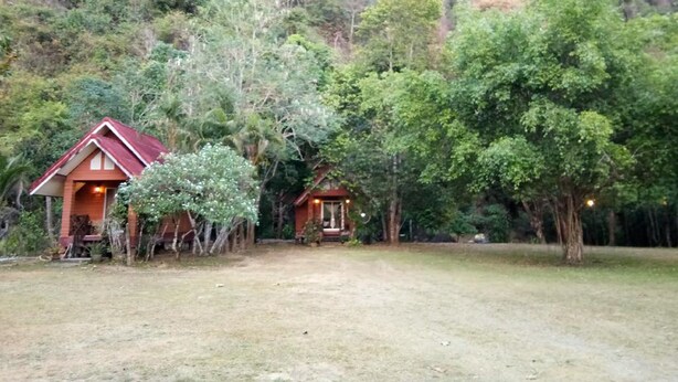 Two cabins surrounded by dense forest with a clear view of a cliff. - Baan Suan Punpaka Resort (La-ngu)