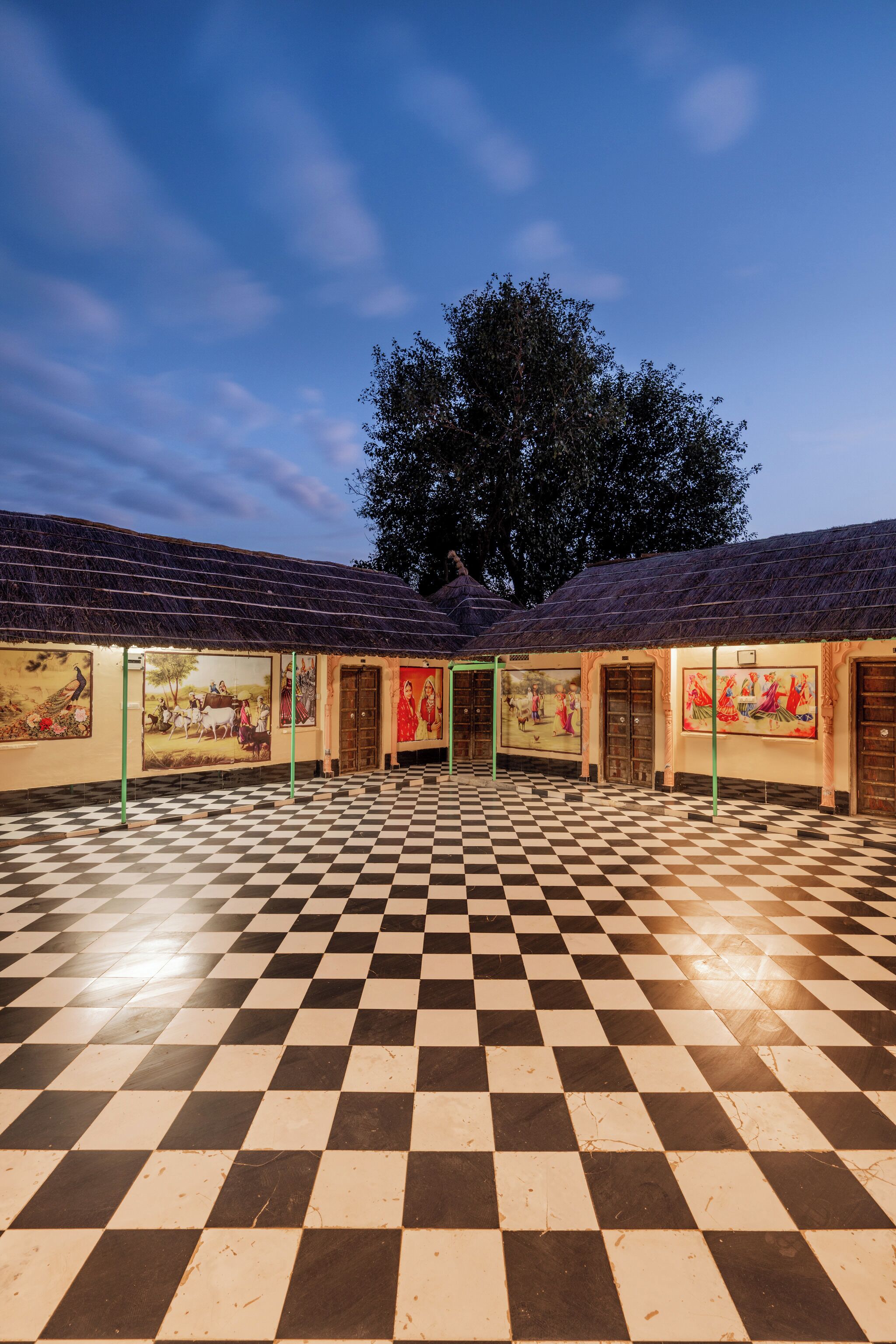 A courtyard with a checkered floor and artwork on the walls.