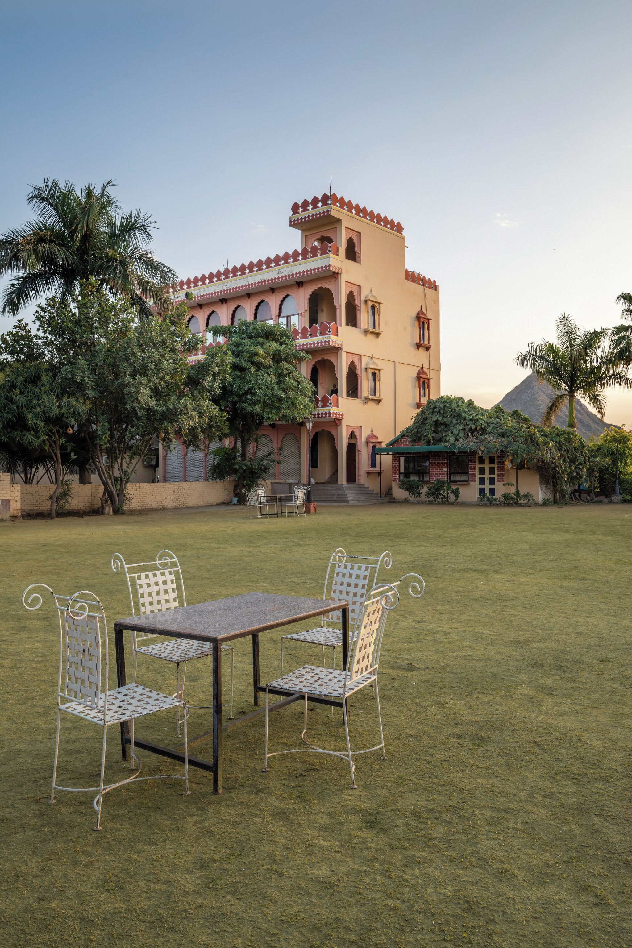 Un edificio de estilo arquitectónico tradicional, con un patio central que incluye una mesa y sillas.