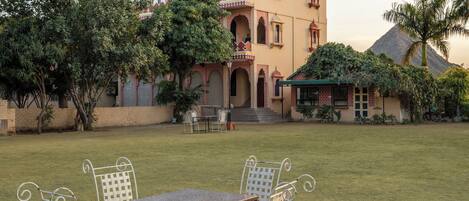 Un edificio de estilo arquitectónico tradicional, con un patio central que incluye una mesa y sillas.