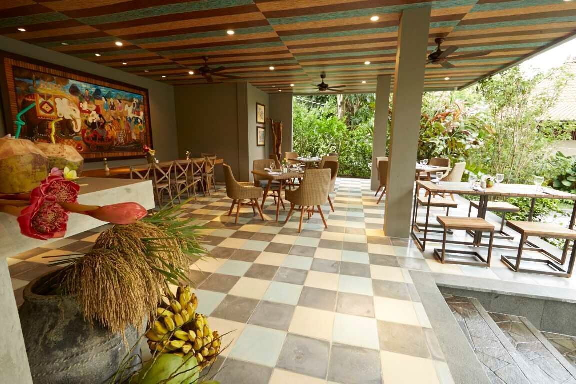 Un restaurante con suelo a cuadros, muebles de madera y un mural en la pared.