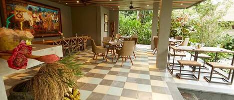 A restaurant with checkered flooring, wooden furniture, and a mural on the wall.