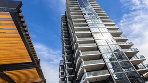 Un edificio moderno de gran altura con varios balcones y ventanas amplias.