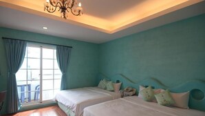 A room with two beds, teal walls, a chandelier, and a view through a window with curtains. - Galilee Bed and Breakfast (Hengchun)