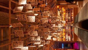 A library with bookshelves filled with books and magazines, wooden bookshelves, and a central aisle.