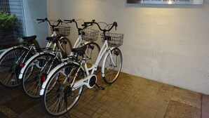 Eine Reihe von Fahrrädern, geparkt an einer Wand, mit einem Schild für das Matsumoto Wellton Hotel.